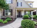 Inviting front entrance with meticulously maintained landscaping, a water feature, and a covered porch at 212 Listening Ridge Ln, Cary, NC 27519