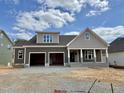 New two-story home with a two-car garage, covered porch, and neutral brown and gray color scheme at 2320 Eagle Shot Ct # 20, Fuquay Varina, NC 27526