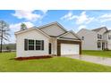 Beautiful single-Gathering home with brick accents, a two-car garage, and lush green lawn at 2736 Luxborough Ln, Mebane, NC 27302