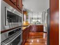 Stylish kitchen with stainless steel appliances, wooden cabinets, tile backsplash, and hardwood flooring at 2817 Peachleaf St, Raleigh, NC 27614