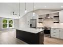 Modern kitchen featuring an island with a marble countertop, pendant lighting, stainless appliances, and hardwood floors at 313 Crown Oaks Dr, Raleigh, NC 27615