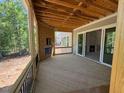 A covered deck with a wood burning fireplace and a view to the living area of the new home at 348 Inspiration Way, Fuquay Varina, NC 27526