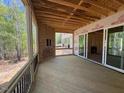 Spacious unfinished deck with wood flooring and black railings, overlooking trees and yard at 348 Inspiration Way, Fuquay Varina, NC 27526