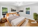 Light-filled bedroom with wood floors and soft, neutral decor featuring a large bed and serene artwork at 3504 Crofton Ct, Raleigh, NC 27604