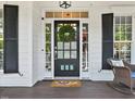 Inviting front door with sidelights and transom, adorned with a wreath, and cozy rocking chair on the porch at 402 Vatersay Dr, Apex, NC 27502