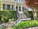 Beautiful home exterior featuring a grand staircase leading to a covered porch and manicured landscaping at 402 Vatersay Dr, Apex, NC 27502