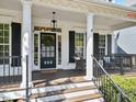 Charming front porch with classic columns, black shutters, and inviting seating area at 402 Vatersay Dr, Apex, NC 27502