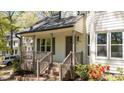 Inviting covered front porch with brick steps and decorative landscaping at the home's entrance at 4936 Liverpool Ln, Raleigh, NC 27604