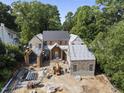 New construction home with brick and stone details and a metal roof, surrounded by trees at 516 Transylvania Ave, Raleigh, NC 27609