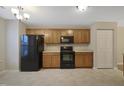 Efficient kitchen with ample cabinet space, black appliances, and neutral tile flooring at 5329 Big Bass Dr, Raleigh, NC 27610