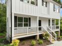 Side view of a white home featuring a cozy porch, wooden stairs, and thoughtfully landscaped garden at 621 Bon Air Ave, Durham, NC 27704