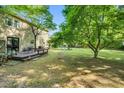 Expansive backyard featuring a wooden deck, mature trees, and ample space for outdoor activities at 704 N Orange Ave, Dunn, NC 28334