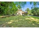 Large, grassy backyard with mature trees, deck, basketball court, and plenty of space for recreation at 704 N Orange Ave, Dunn, NC 28334