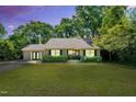 Inviting single-story home at twilight, showcasing a well-kept lawn and an illuminated, welcoming front entrance at 704 N Orange Ave, Dunn, NC 28334