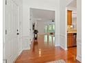 Inviting foyer with hardwood floors, white wainscoting, and views into the living spaces at 803 Footbridge Pl, Cary, NC 27519