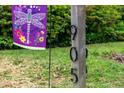 Close-up of the house numbers, '905', on a wooden post beside a decorative dragonfly flag at 905 Cindy St, Cary, NC 27511