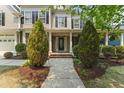 Inviting front porch with a decorative front door, column supports, and landscaped yard at 909 Grogans Mill Dr, Cary, NC 27519