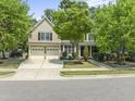 Charming two-story home with a two car garage and landscaped front yard, including lush green trees at 909 Grogans Mill Dr, Cary, NC 27519