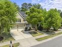Charming two-story home with a two car garage and landscaped front yard, including lush green trees at 909 Grogans Mill Dr, Cary, NC 27519