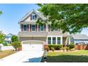 Charming two-story home featuring a two-car garage and manicured front lawn with garden at 112 Gadsbury Dr, Holly Springs, NC 27540