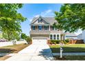 Two-story home boasts a manicured lawn, two-car garage, and classic shuttered windows at 112 Gadsbury Dr, Holly Springs, NC 27540