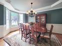 Formal dining room featuring elegant wainscoting, a chandelier, and large windows with natural light at 113 Chesterfield Dr, Cary, NC 27513