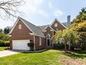 Charming brick home featuring a lush lawn and a two-car garage on a sunny day at 117 Whitehaven Ln, Cary, NC 27519