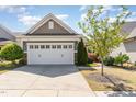 Attached two-car garage with white door, stone accents, and manicured front yard at 1206 Areca Way, Durham, NC 27703