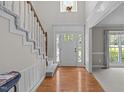 Bright foyer with hardwood floors, a staircase, and a view into the living area at 1408 Bridgeport Dr, Raleigh, NC 27615