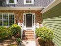 Close-up of the front entrance, showcasing the brick steps and manicured bushes at 1408 Bridgeport Dr, Raleigh, NC 27615