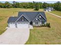 Aerial view of a home with large yard space, well manicured lawn, and a three car garage at 194 Spring Hill Church Rd, Lillington, NC 27546