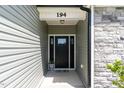 Close up of home's front door featuring stone accents and a welcome mat at 194 Spring Hill Church Rd, Lillington, NC 27546