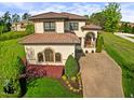 Attractive stucco house with a tile roof, lush landscaping, and a brick driveway at 20 Al Aqua Dr, Durham, NC 27707
