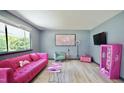 Stylish living room featuring a vibrant pink couch, playful decor, and lots of natural light at 2006 Waters Dr, Raleigh, NC 27610