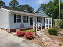 Close up of a quaint house with stone pavers, colorful landscaping, and a welcoming front entrance at 206 Lane Of Tristram, Garner, NC 27529