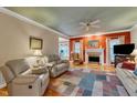 Cozy living room with a fireplace, comfortable seating, ceiling fan, and hardwood floors at 208 E Harrington Ave, Broadway, NC 27505