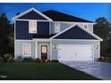 Charming two-story home with a combination of blue and grey siding and a two-car garage at 2233 Cherry Creek Rd, Haw River, NC 27258