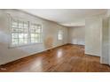 A vacant living room showcasing hardwood floors, natural light, and plain white walls at 2343 Derby Dr, Raleigh, NC 27610