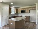 Well-lit kitchen featuring an island, wood cabinets, granite countertops, and stainless steel appliances at 261 Phil Jack Rd, Dunn, NC 28334