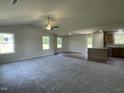 Spacious living room with plush carpeting, a ceiling fan, and an adjacent kitchen area at 261 Phil Jack Rd, Dunn, NC 28334