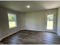 Brightly lit bonus room with wood-style flooring and a glass paneled door leading outside at 261 Phil Jack Rd, Dunn, NC 28334