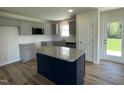 Modern kitchen with gray cabinets, granite counters, stainless steel appliances, and a center island at 299 Phil Jack Rd, Dunn, NC 28334