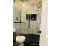 Modern bathroom featuring a glass walk-in shower with marble tile, and black fixtures at 3018 Green Hill Dr, Chapel Hill, NC 27514