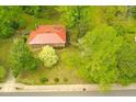 Aerial view of home featuring a red metal roof and a lush green yard with mature trees at 311 N Nash St, Hillsborough, NC 27278
