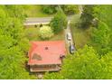 Bird's-eye view of a home with a red metal roof, a long driveway, and a spacious yard with ample parking at 311 N Nash St, Hillsborough, NC 27278
