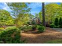 A beautiful brick home surrounded by lush greenery and mature trees at 3203 Cameron Dr, Henderson, NC 27536