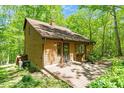 Charming home exterior featuring wood siding, brick patio, and lush green landscaping at 3605 Moonlight Dr, Chapel Hill, NC 27516