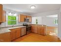 Bright kitchen boasts stainless steel appliances, wood cabinets and hardwood flooring at 3605 Moonlight Dr, Chapel Hill, NC 27516