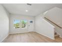 Bright living room with wood-look floors, multiple windows and staircase at 3705 Rosebush Dr, Zebulon, NC 27597