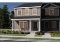 Exterior elevation of a two-story new construction home with neutral colors and a covered front porch and green landscaped yard at 3711 Rosebush Dr, Zebulon, NC 27597